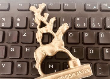 Kleine Bronze-Skulptur der Bremer Stadmusikanten auf einer PC-Tastatur