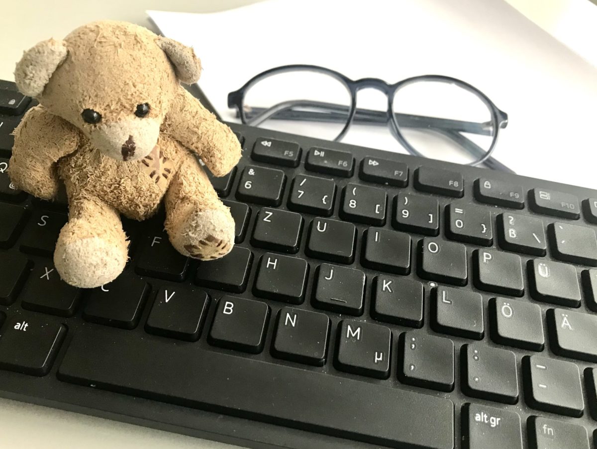 Tastatur mit kleinem Teddy und einer Lesebrille