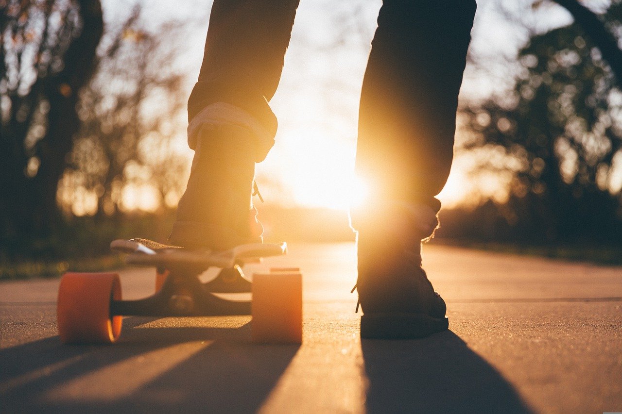 Kind auf einem Skateboard vor Sonnenuntergang